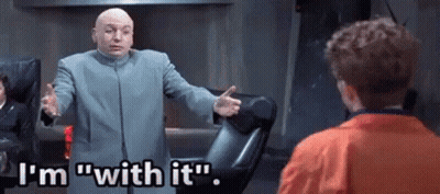 A Bald Man In A Suit Is Talking To A Young Boy In An Orange Jacket . GIF
