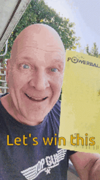 A Bald Man In A Top Gun Shirt Is Holding Up A Yellow Powerball Ticket GIF