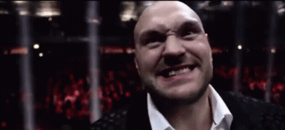 A Bald Man In A White Shirt Is Smiling In Front Of A Crowd GIF