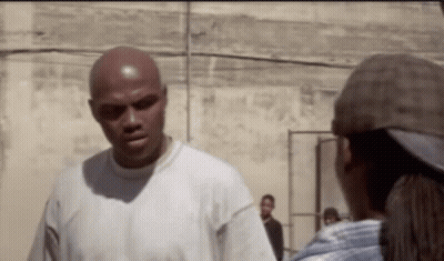 A Bald Man In A White Shirt Is Talking To A Woman In A Hat . GIF