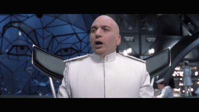 A Bald Man In A White Uniform Has His Mouth Open In A Room GIF