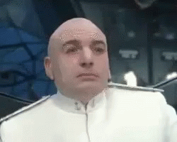 A Bald Man In A White Uniform Is Looking At The Camera GIF