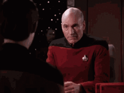 A Bald Man Is Covering His Face With His Hands While Another Man Looks On GIF