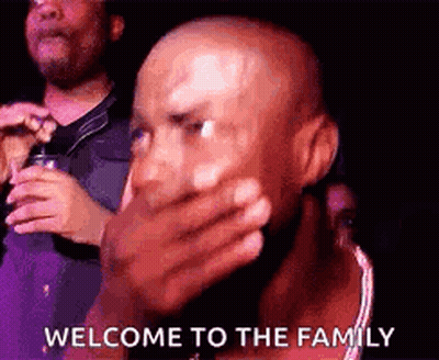 A Bald Man Is Covering His Mouth With His Hand And The Words `` Welcome To The Family '' . GIF