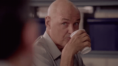 A Bald Man Is Drinking A Cup Of Coffee From A Plastic Cup . GIF