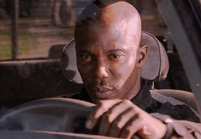 A Bald Man Is Driving A Car And Looking At Something GIF