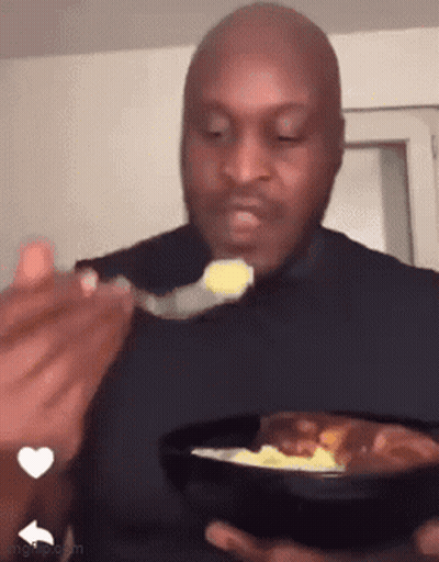 A Bald Man Is Eating Food With A Spoon From A Bowl . GIF
