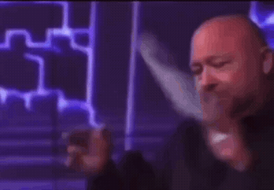 A Bald Man Is Holding A Cell Phone In His Hand And Says Liberal . GIF
