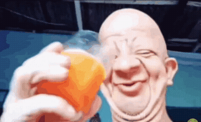 A Bald Man Is Holding A Cup Of Orange Juice And Smiling GIF