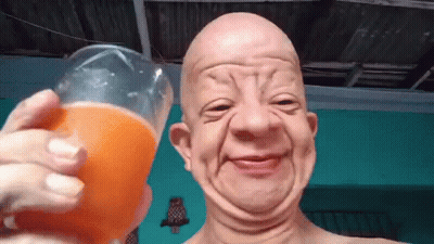 A Bald Man Is Holding A Glass Of Orange Juice And Making A Face . GIF