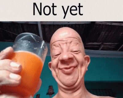 A Bald Man Is Holding A Glass Of Orange Juice And Smiling GIF