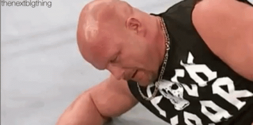 A Bald Man Is Laying On The Ground Wearing A Black Tank Top That Says `` Rock N ' Roll '' . GIF