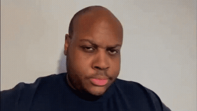 A Bald Man Is Making A Funny Face While Pointing At The Camera . GIF