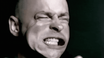 A Bald Man Is Making A Funny Face With His Eyes Closed . GIF