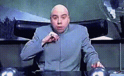 A Bald Man Is Sitting At A Desk With His Hand On His Chin GIF