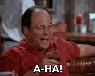 A Bald Man Is Sitting At A Table With A Glass Of Wine And Laughing . GIF