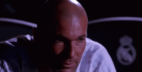 A Bald Man Is Sitting In A Dark Room With The Words `` C ' Est Les Émotions '' Written On The Screen . GIF