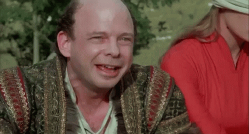 A Bald Man Is Smiling With The Words " You Fell Victim " Behind Him GIF