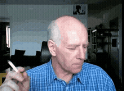 A Bald Man Is Smoking A Cigarette In A Blue Plaid Shirt GIF