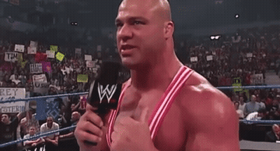 A Bald Man Is Standing In A Boxing Ring With His Arms Outstretched . GIF