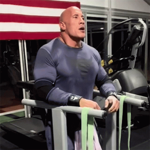 A Bald Man Is Standing On A Treadmill Wearing A Shirt That Says Superman GIF