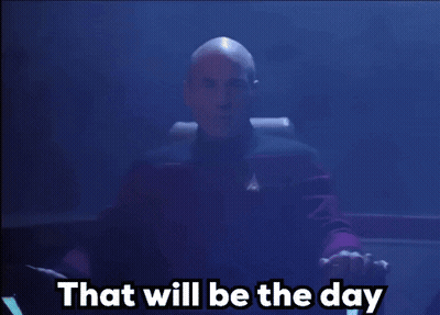 A Bald Man Sitting In A Chair With The Words That Will Be The Day Behind Him GIF