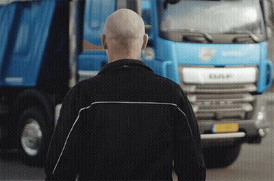A Bald Man Stands In Front Of A Daf Truck GIF