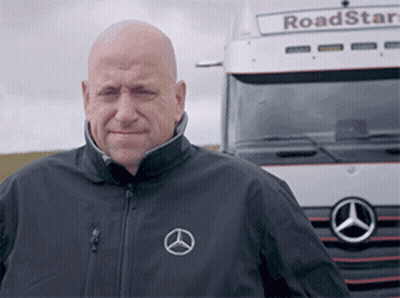 A Bald Man Stands In Front Of A Mercedes Truck GIF