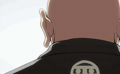 A Bald Man Wearing A Black Jacket With The Letter G On The Back Of It GIF