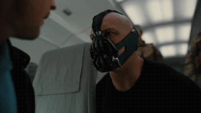 A Bald Man Wearing A Mask Talks To Another Man GIF