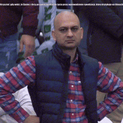 A Bald Man Wearing A Plaid Shirt And A Vest Is Looking At The Camera With His Hands On His Hips GIF