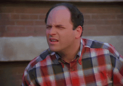 A Bald Man Wearing A Plaid Shirt Is Making A Face GIF
