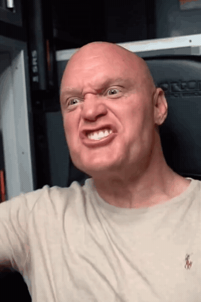A Bald Man Wearing A Polo Shirt Is Making An Angry Face GIF
