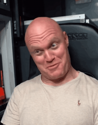 A Bald Man Wearing A Polo Shirt Makes A Face GIF