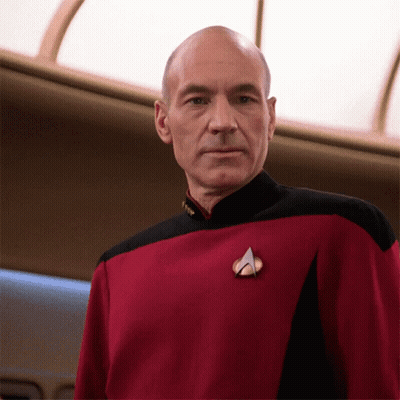 A Bald Man Wearing A Red And Black Uniform With A Badge That Says " Captain " GIF