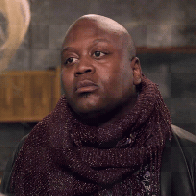A Bald Man Wearing A Scarf And A Jacket GIF
