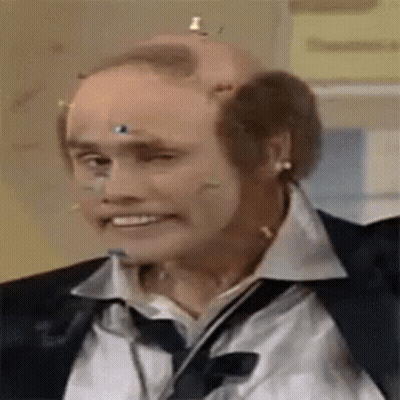 A Bald Man Wearing A Suit And Tie Has A Bunch Of Wires Stuck To His Head . GIF