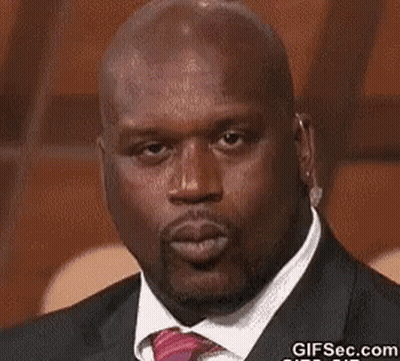 A Bald Man Wearing A Suit And Tie Is Blowing A Kiss . GIF
