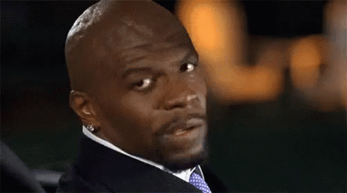 A Bald Man Wearing A Suit And Tie Is Looking At The Camera . GIF