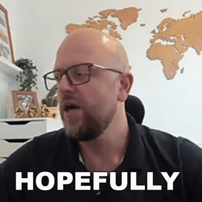 A Bald Man Wearing Glasses And A Black Shirt Says Hopefully In Front Of A Map Of The World . GIF