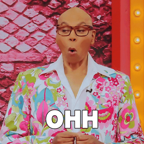 A Bald Man Wearing Glasses And A Colorful Floral Suit Says Ohh GIF