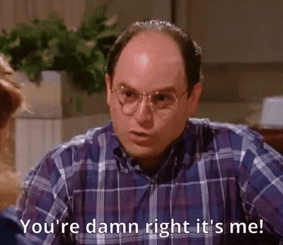A Bald Man Wearing Glasses And A Plaid Shirt Is Talking To A Woman . GIF