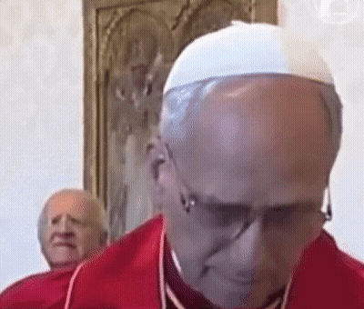 A Bald Man Wearing Glasses And A White Hat Looks Down GIF