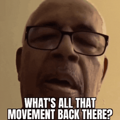A Bald Man Wearing Glasses Is Asking What 'S All That Movement Back There . GIF
