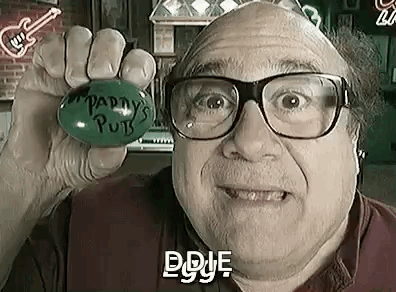 A Bald Man Wearing Glasses Is Holding A Green Ball In His Hand In A Bar . GIF