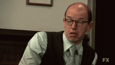 A Bald Man Wearing Glasses Is Making A Funny Face . GIF