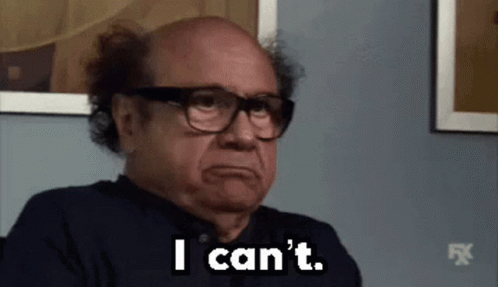 A Bald Man Wearing Glasses Is Sitting In Front Of A Wall And Says `` I Can 'T '' . GIF