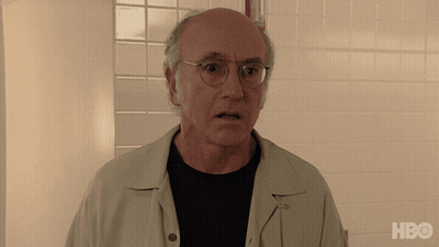 A Bald Man Wearing Glasses Stands In Front Of A White Tiled Wall With The Hbo Logo On The Bottom GIF