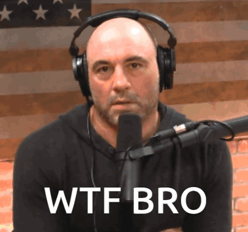 A Bald Man Wearing Headphones Stands In Front Of A Microphone With The Words Wtf Bro Written On His Face GIF