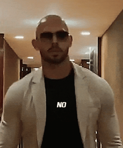 A Bald Man Wearing Sunglasses And A Black Shirt With The Word No On It GIF